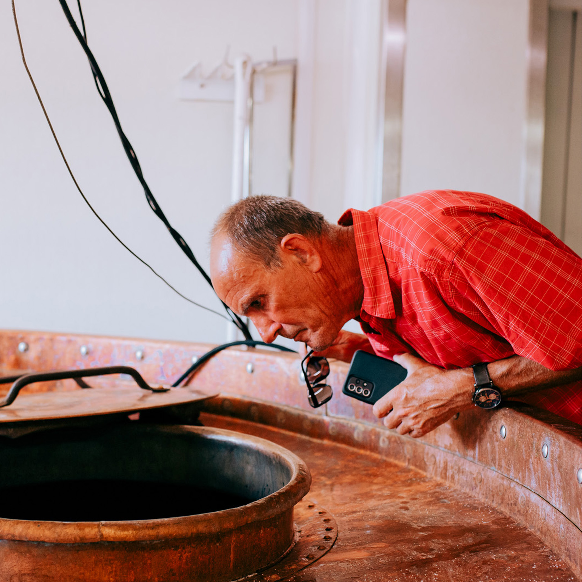 visiteur inspectant une cuve en cuivre